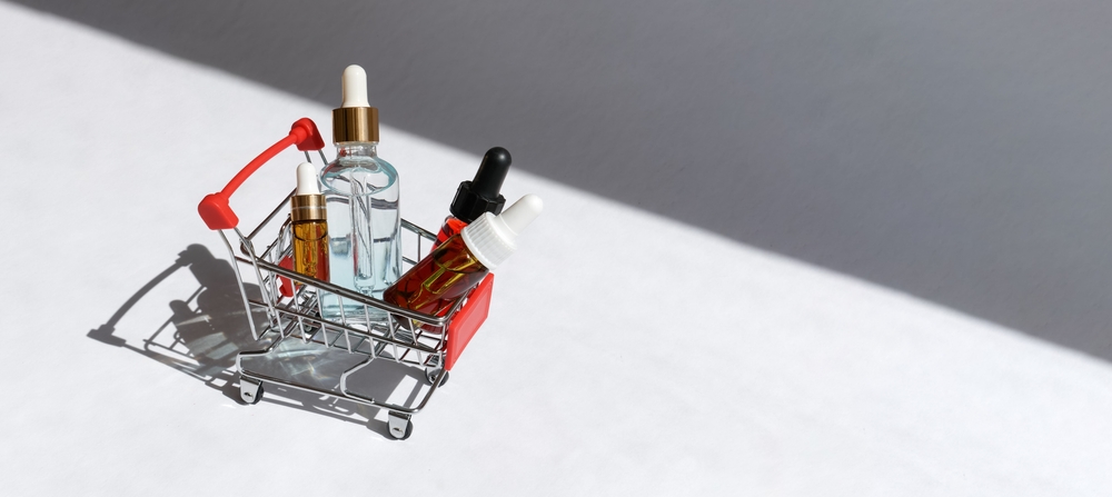 Online,Shopping,Minimalistic,Concept.,Small,Cart,With,Cosmetic,Bottles.,Essential